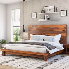 a large bed sitting on top of a wooden floor next to a white and black rug