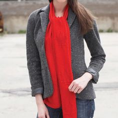 a woman wearing a gray jacket and red scarf