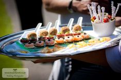 a platter filled with assorted appetizers on top of a metal tray