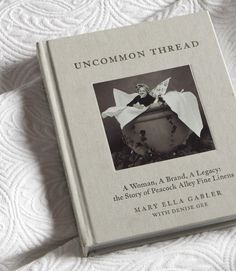 the book uncommon thread is laying on top of a white bed sheet with an image of a woman in a bow tie