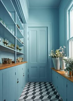 a room with blue walls and shelves filled with vases