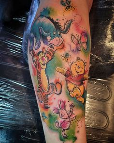 winnie the pooh and friends watercolor tattoo on leg with colored inks in it