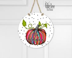 a colorful painted pumpkin hanging from a door