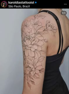 the back of a woman's shoulder with flowers on it and leaves in the middle