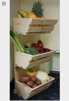 three wooden crates stacked on top of each other with fruits and vegetables in the bottom