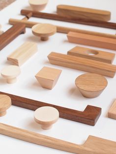 various wooden objects are arranged on a white surface with wood trimmings around them