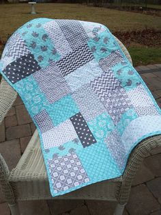 a blue and gray quilt sitting on top of a chair