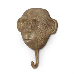 a brass monkey head hook on a white wall