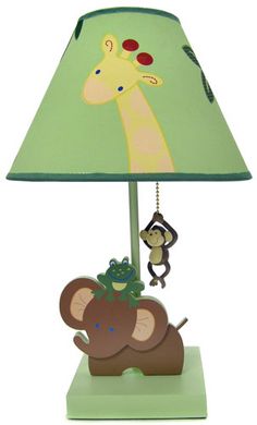 a lamp with a green shade on top of it and two monkeys hanging from the bottom