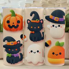 three crocheted halloween mugs with cats and pumpkins on them