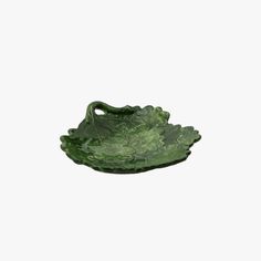 a green leaf shaped dish on a white background