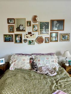 a bed with many pictures on the wall above it