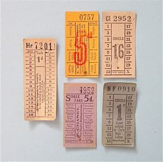 four tickets with numbers on them sitting next to each other in front of a white background