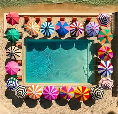 an overhead view of colorful umbrellas and chairs by the swimming pool, taken from above