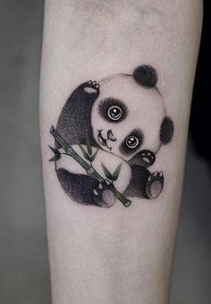 a black and white panda bear holding bamboo on the right arm with eyes wide open