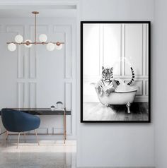 a black and white photo of a cat sitting in a bathtub next to a chair