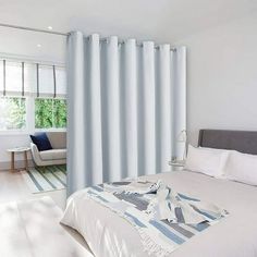 a bedroom with white walls and blue curtains