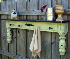 a towel rack with two towels hanging from it's sides, next to a fence