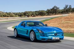 a blue mercedes sls amg driving down the road