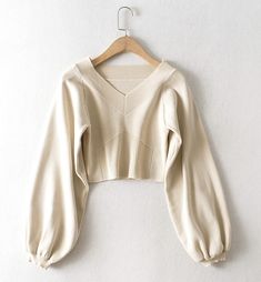 The Cream Balloon Sleeve Knit Sweater is a stylish addition to any wardrobe, offering a blend of comfort and contemporary fashion. This sweater features an elegant V-neckline and unique geometric ribbed detailing on the front, adding a touch of sophistication to its casual appeal. The soft cream color makes it versatile and easy to pair with a variety of outfits, whether youre dressing up for a day out or keeping it cozy at home.Crafted from high-quality knit fabric, this sweater ensures a comfo Solid Ribbed V-neck Knit Top, Beige Knitted V-neck Cardigan, Chic Textured Knit V-neck Cropped Sweater, Chic V-neck Textured Knit Cardigan, Spring V-neck Stretch Sweater, Stretch Ribbed V-neck Sweater, Beige Knit V-neck Cardigan, Trendy Stretch V-neck Cardigan, Trendy V-neck Knit Top For Fall