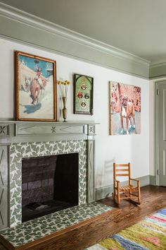 a living room with a fire place and pictures on the wall above it's mantle