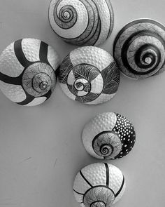 black and white photograph of several balls with spiral designs on the top one is spinning around