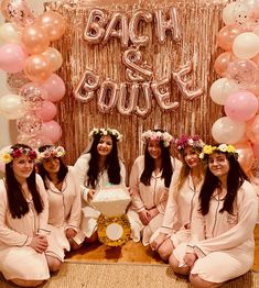 the bride and her bridesmaids pose for a photo in front of a backdrop with balloons