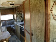 the inside of an rv with wood paneling on the walls and cabinets in it