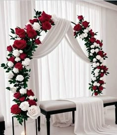 a wedding arch decorated with red and white flowers