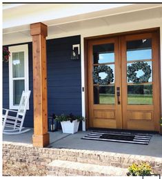 the front porch is decorated with wreaths and rocking chairs