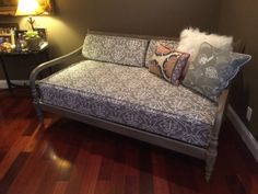 a couch sitting on top of a hard wood floor next to a table and lamp