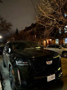 a black suv parked on the street at night