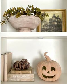 two shelves with pumpkins and books on them