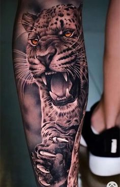 a man's leg with a tattoo of a leopard and a tiger on it