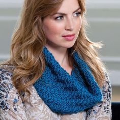 a woman with long hair wearing a blue knitted cowl scarf over her shoulder