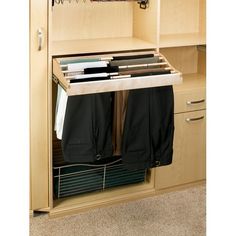 an open cabinet with clothes hanging on it