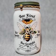 This beautiful handmade mason jar is perfect for displaying artificial or real flowers, as a tissue holder, or a tealight candle holder. The jar features a lovely sunflower and bee design with the words "Bee Kind, Bee Positive, Bee Grateful" adorning the front. Product Details: Size: Quart (other sizes available upon request) Versatile Use: Safe for real flowers, tissues, or tealights Care Instructions: Clean with a damp cloth   This unique and charming jar makes a wonderful gift or a lovely addition to your own home decor. Order yours today! Spring Mason Jar Crafts, Repurposed Jars, Crafts That Sell, Spring Mason Jar, Sunflower And Bee, Bee Positive, Diy Honey, Pot Decor, Honey Diy