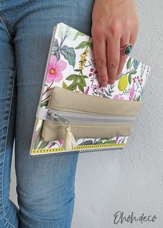 a woman's hand is holding a purse with flowers on the front and sides