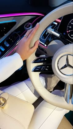 the interior of a car with a woman's hand on the steering wheel