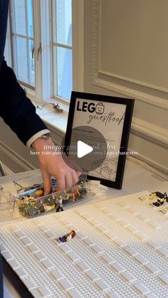 a man in a suit and tie is working on a lego model with his hands