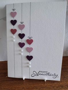 an anniversary card with hearts hanging from strings