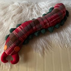 a stuffed caterpillar is laying on the floor