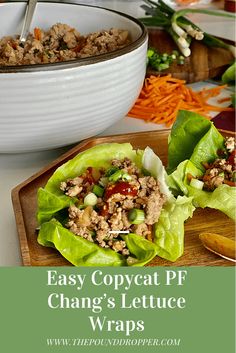 two lettuce wraps filled with meat and vegetables on a cutting board next to a bowl of carrots