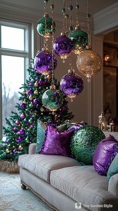 a living room filled with lots of purple and green christmas ornaments hanging from the ceiling