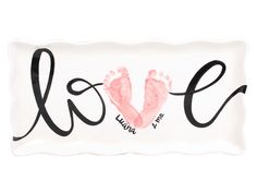 a plate with the word love written in cursive writing and a pink handprinted foot