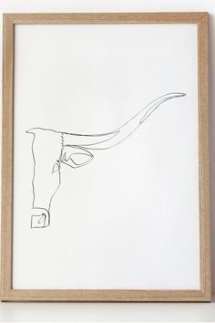 a black and white drawing of a cow's head in a wooden frame on the wall