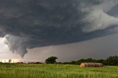 a large storm is coming in over a grassy field