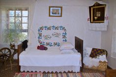 a small bed in a room with white walls and rugs on the floor next to it