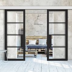 an open glass door leading to a bedroom with a bed in the corner and a bench on the other side