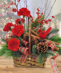 a basket filled with red flowers and pine cones